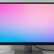 Professional monitor screen split to compare uncalibrated and calibrated display with LED screen calibration tool in foreground